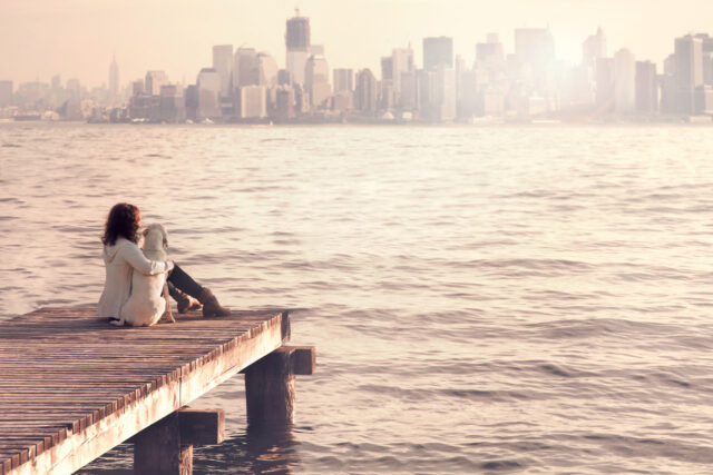 woman embracing sweetly her dog while looking NewYork city